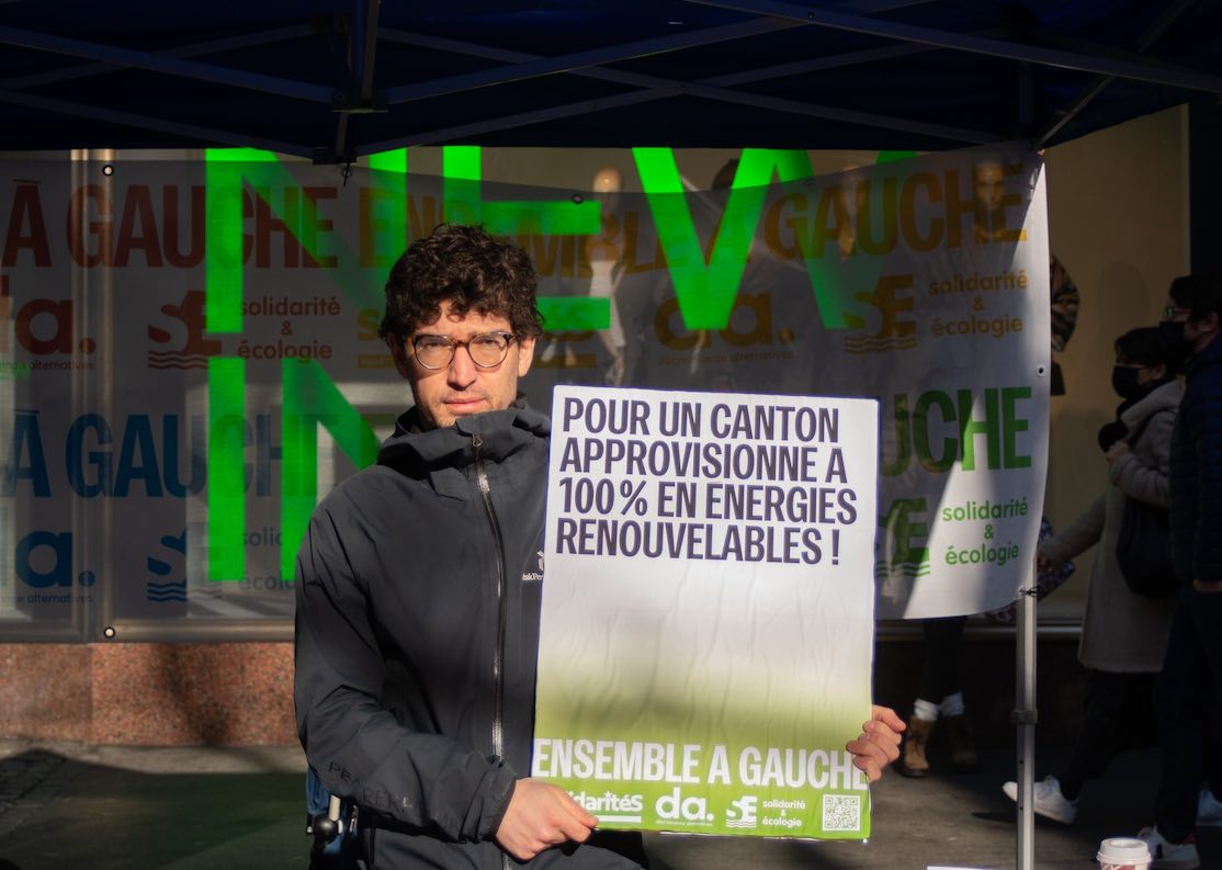 Le député au Grand Conseil vaudois Hadrien Buclin tient une pancarte "Pour un canton approvisioonné à 100% en énergies renouvelables"