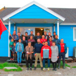 Militantes du parti Inuit Ataqatigiit du Groenland devant une habitation typique