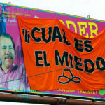 Panneau électoral représentant Daniel Ortega recouvert par des protestataires
