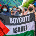 Deux femmes tiennent une banderole "Boycott Israël" lors de la manifestaiotn du 15 mai 2021 à Genève