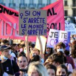 Une manifestante féministe porte une pancarte "Si on s'arrête, le monde s'arrêtre"
