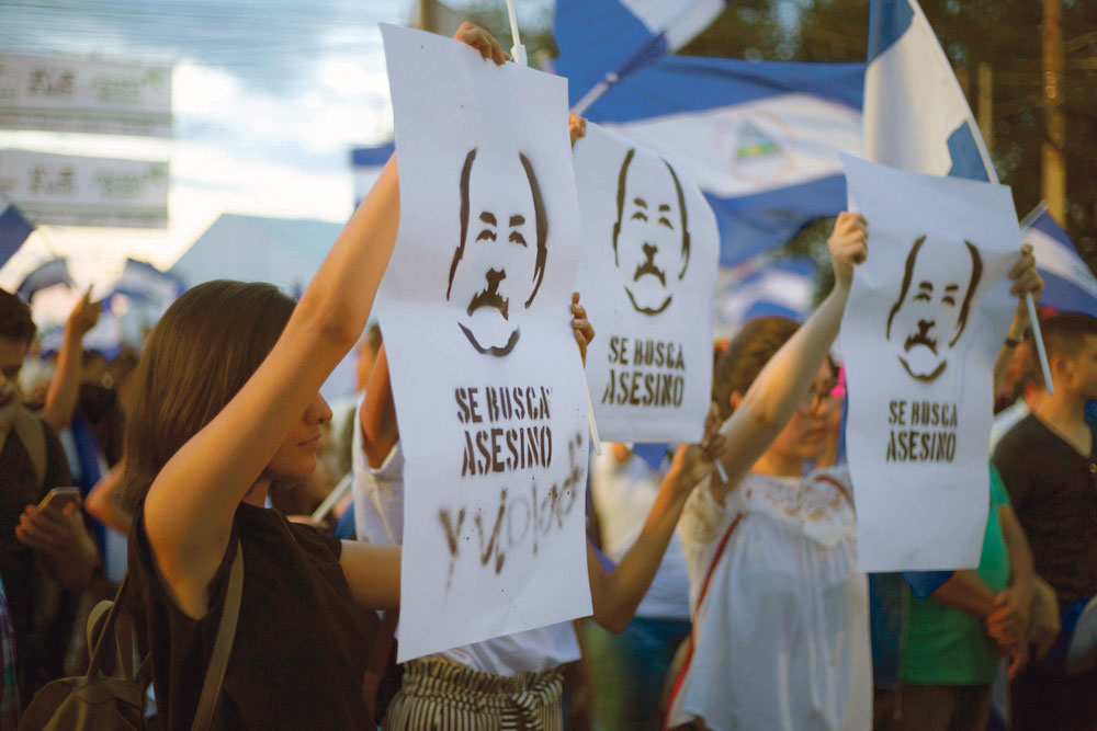 Des manifestantes portent des pancartes avec le portrait de Daniel Ortega