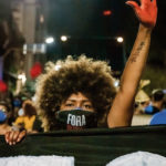 Une manifestante lève une main peinte en rouge pour protester contre le gouvernement Bolsonaro au Brésil