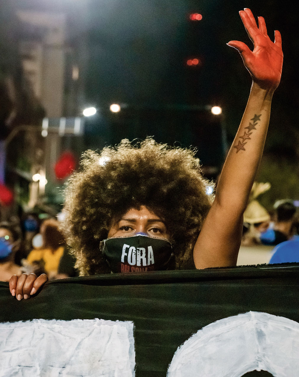 Une manifestante lève une main peinte en rouge pour protester contre le gouvernement Bolsonaro au Brésil