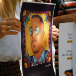 Une manifestante tient un portrait d'Adil Belakhdim, Lausanne