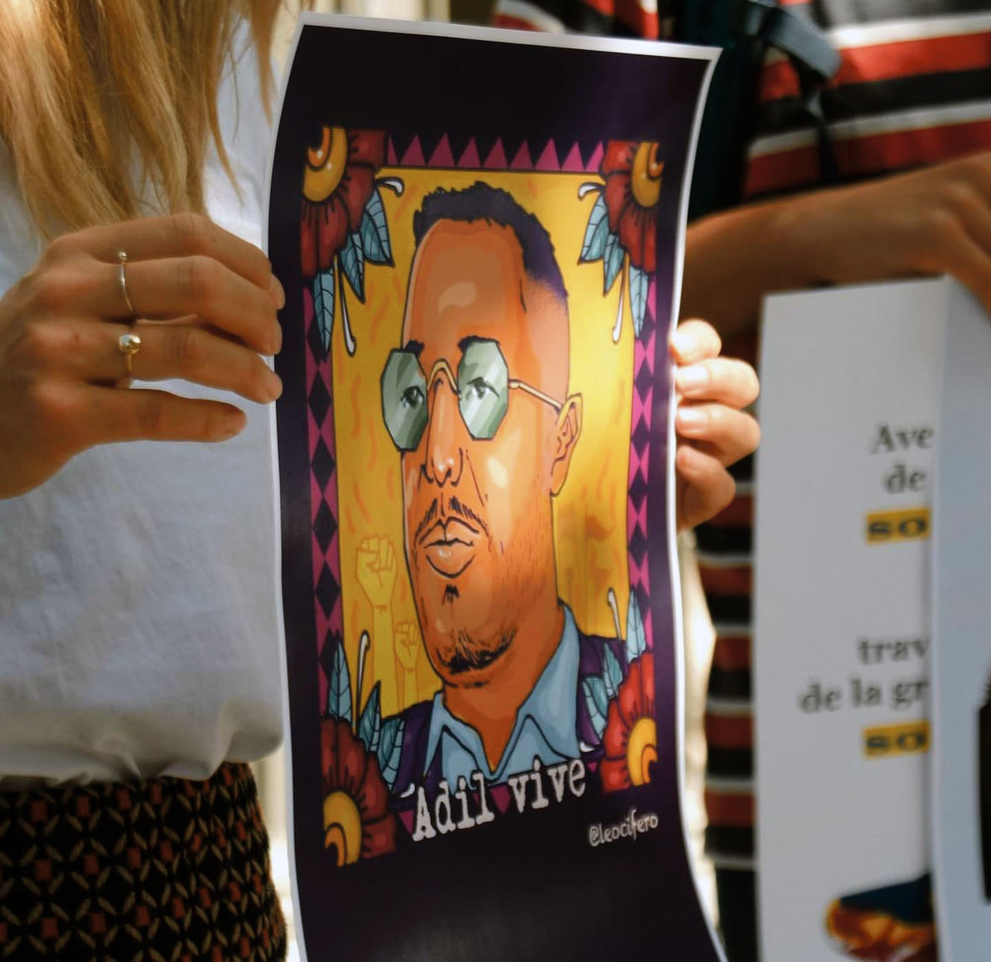 Une manifestante tient un portrait d'Adil Belakhdim, Lausanne