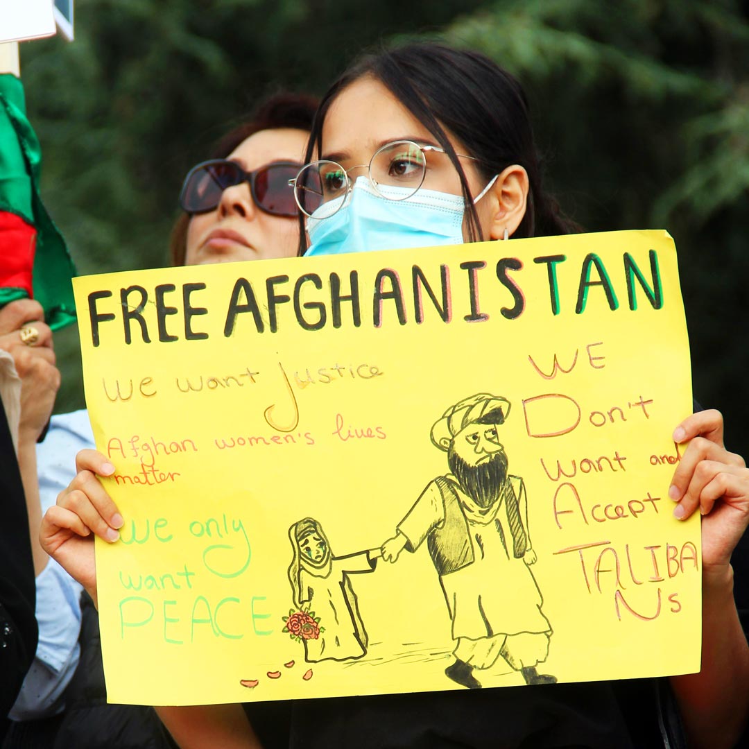 Une manifestante porte un panneau Free Afghanistan
