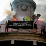 Des manifestants à Paris portent une banderole Contre le fascisme, l'Etat et le capital.
