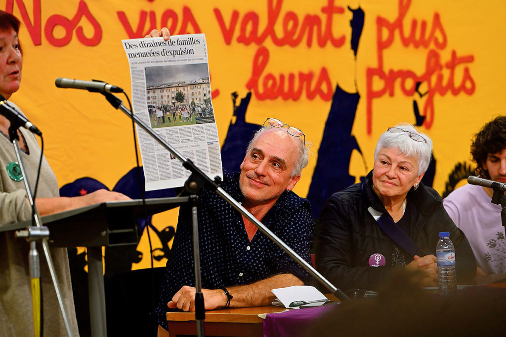 Philippe Poutou , candidat à la présidentielle française devant une banderole "nos vies vlalent plus que leurs profits"