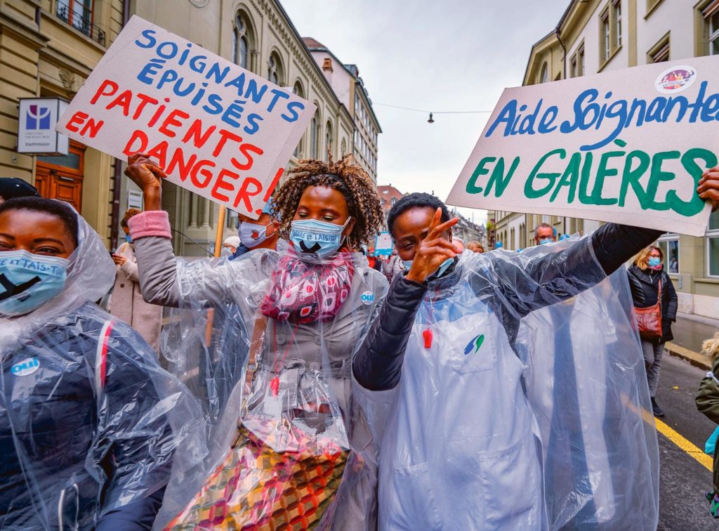 Des aides-soignante portent des pancartes 'soignants épuisés patients en danger'