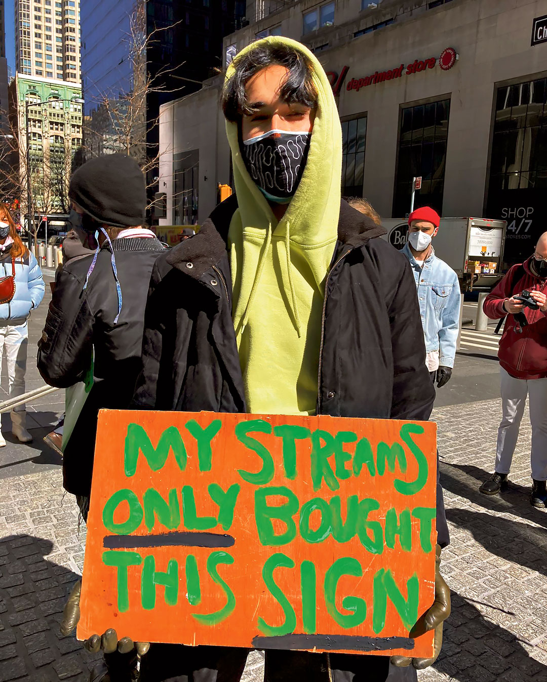 Un manifestant tient une pancarte "My streams only bought this sign" à New York