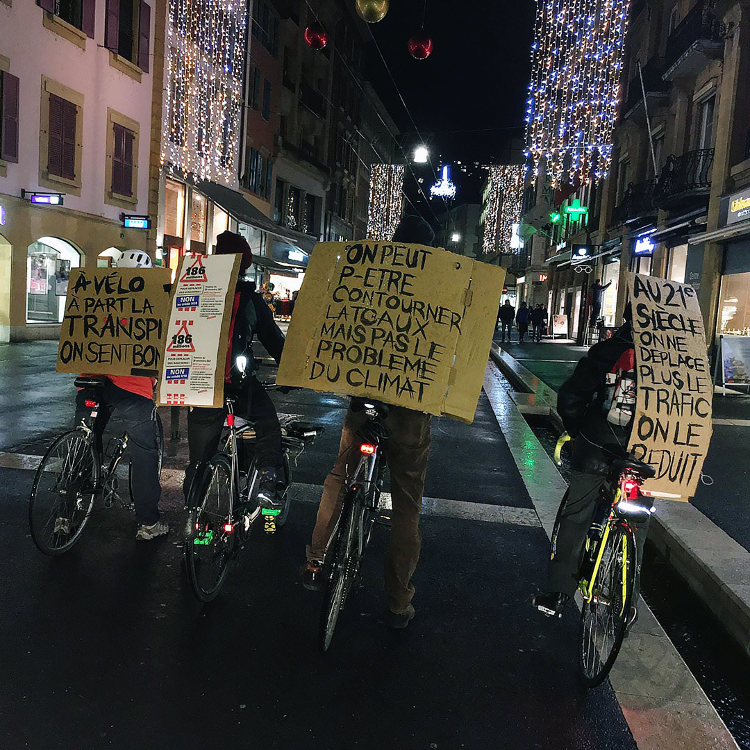 Vélos portant des pancartes contre la construction de'une route de contournement