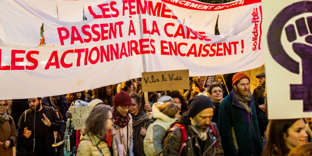 manifestants à Lausanne avec une banderole Les femmes passent à la caisse les actionnaires encaissent