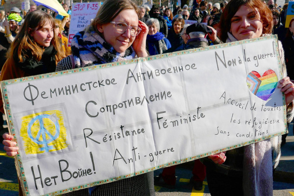 Des manifestantes tiennent une banderole contre la guerre en Ukraine