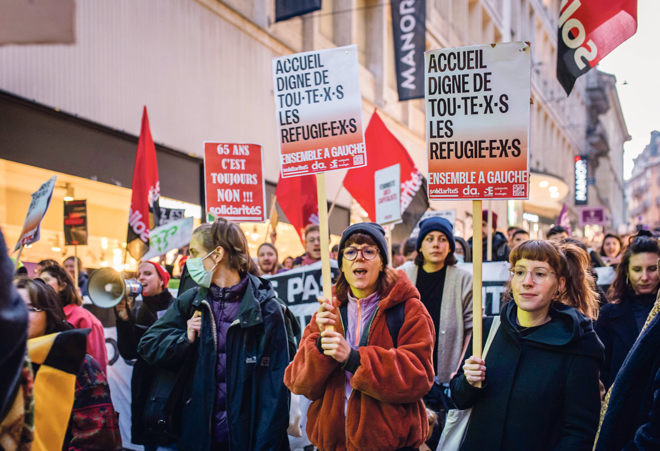 Des manifestantes féministes portent des pancartes pour l'accueil des réfugiés