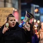 Une manifestante tient un mégaphone
