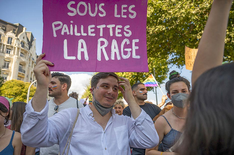 Un manifestant avec une pancarte "Sous les paillettes, la rage"