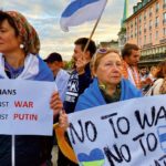 Manifestantes tenant des pancartes contre la guerre en Ukraine