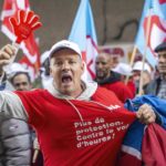 Un maçon en grève montre son t-shirt avec le slogan "Plus de protection. Contre le vol d'heures" à Genève