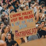 Une pancarte au milieu du défilé de la grève des femmes dit: "L’homme violent n’est pas malade, il est un fils sain du patriarcat”