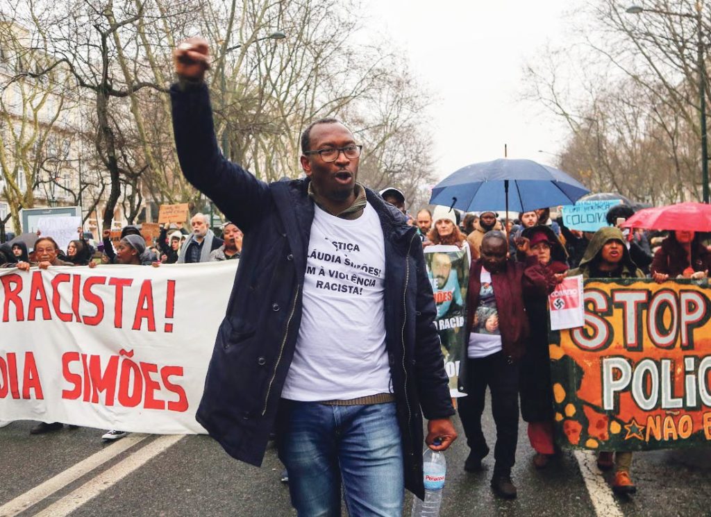 Mamadou Ba lève le poing lors d'une manifestation antiraciste