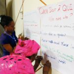 Deux femmes écrivent des phrases à propos de la dette en Afrique