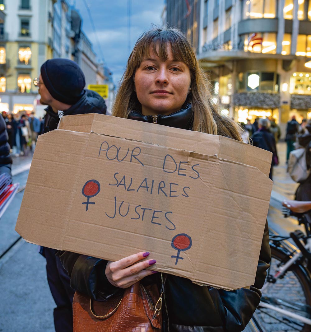 Une manifestante tient une pancarte: Pour des salaires justes