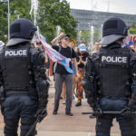 Deux policiers bloquent des manifestantes LGBTIQ