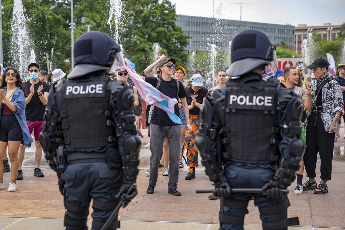 Deux policiers bloquent des manifestantes LGBTIQ qui protestent contre la visite de Posie Parker à Genève