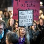 Une femme tient une pancarte #noustoutes brisons le silence et les violences