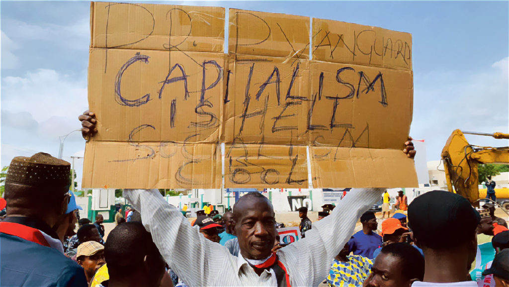 Un manifestant nigérian tient une pancarte contre le capitalisme