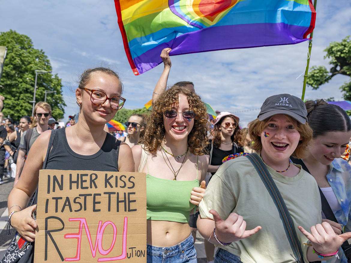 Des manifestantes lors de la Pride 2023 à Genève. Banderole: "dans son baiser, je goûte la révolution"