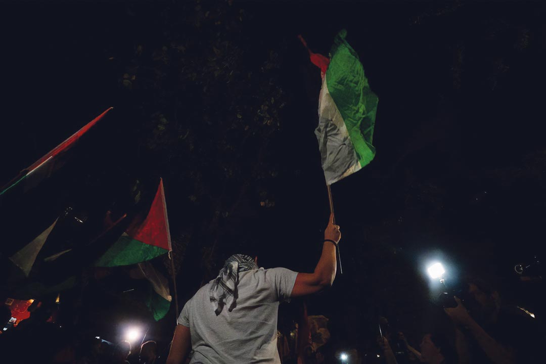 Un manifestant agite un drapeau palestinien pour protester contre la répression à la suite de l'attaque du Hamas