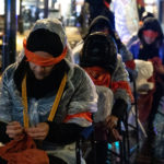 Des manifestantes tricotent les yeux bandés lors de la grève des soins