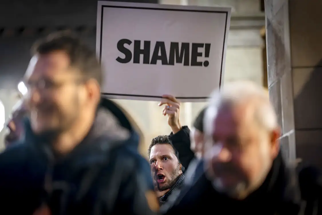 Un enseignant genevois tient un panneau “shame” pour dénoncer la politique d'austérité du canton de Genève