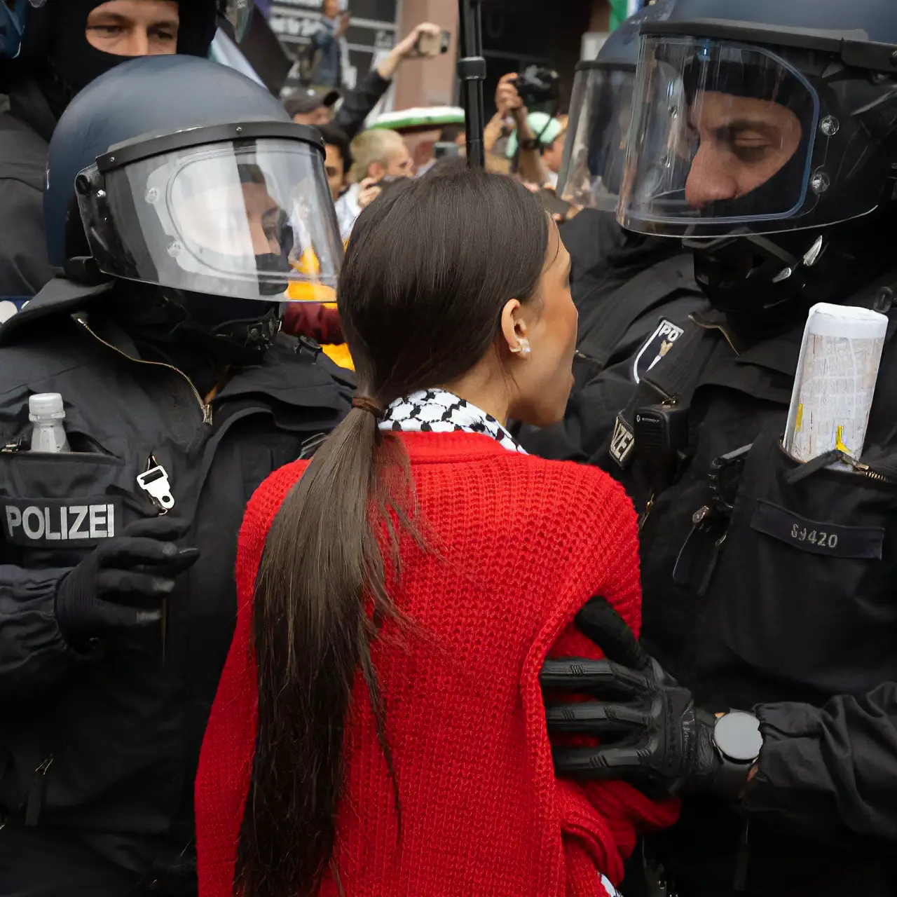 Une manifestant enrouée de deux policiers lors d'une manifestation commémorant la Nakba en Palestine à Berlin