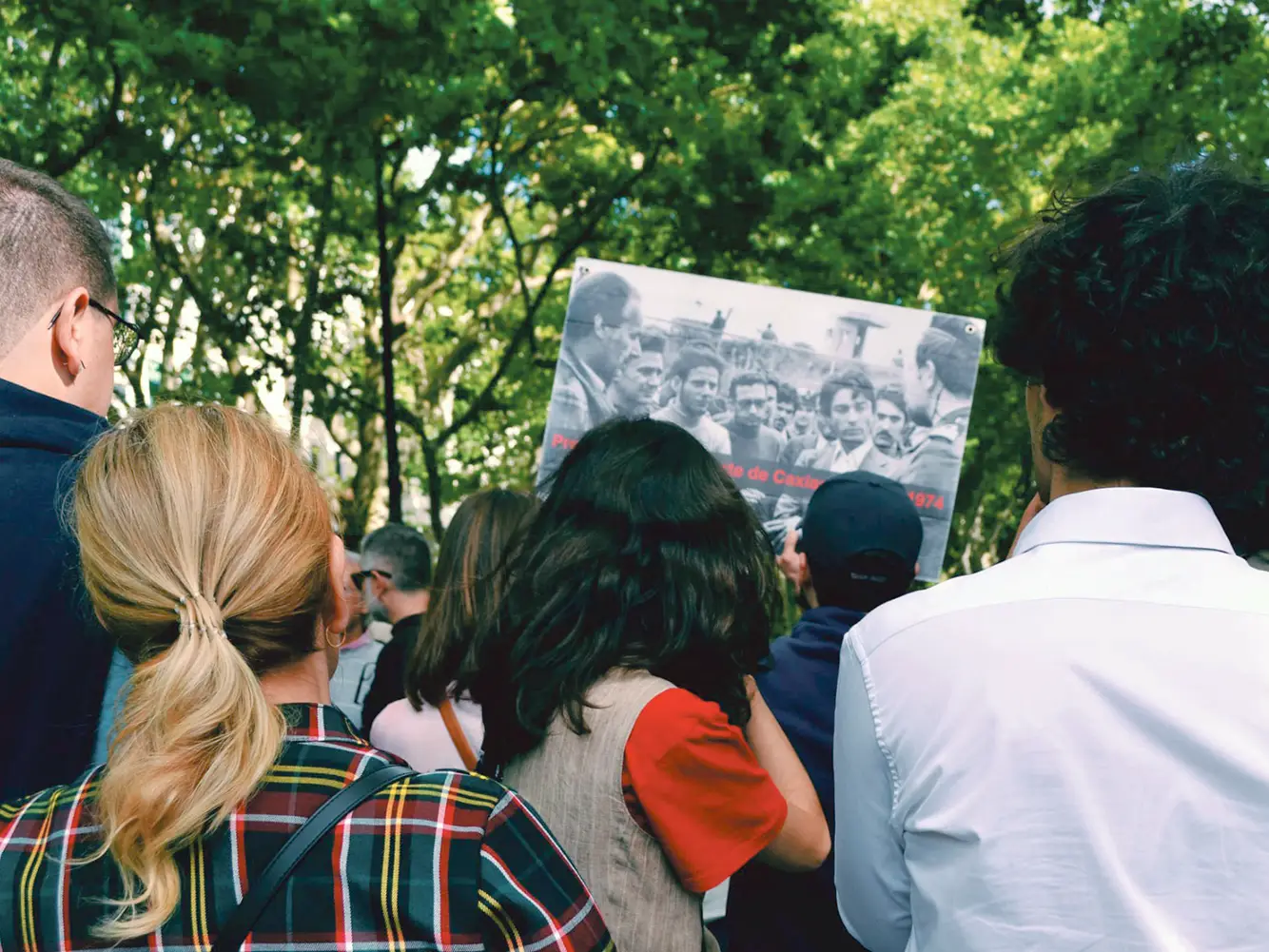 Des manifestants célébrant les 50 ans de la Révolution des Œillets au Portugal tenant une photo historique