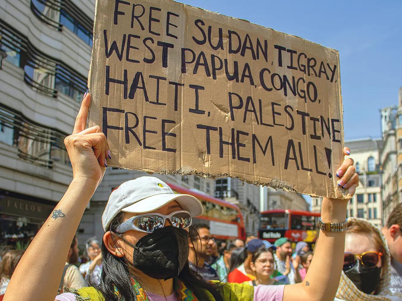 Une manifestante tient une pancarte "Free Sudan, Tigray, West Papua, Congo, Haiti, Palestine. Free them all” lors d'une marche pour le Soudan