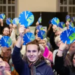 Des personnes brandissent le symbole de l’initiative Responsabilité environnementale