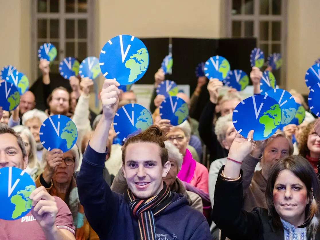 Des personnes brandissent le symbole de l’initiative Responsabilité environnementale