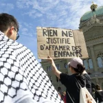 Une manifestante tient une banderole "rien ne justifie d'affamer des enfants"
