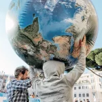 Des personnes portent un globe terrestre lors d'un rassemblement pour la biodiversité