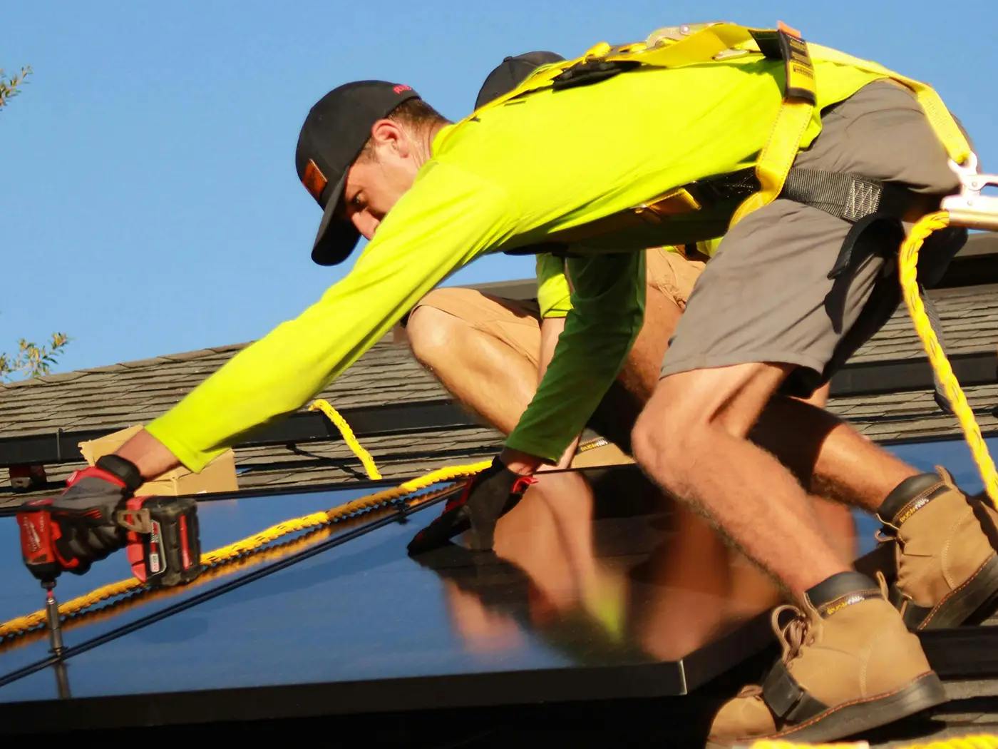 Un homme installe un panneau solaire sur un toit