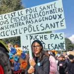 Une manifestante tient une pancarte contre la diminution d'argent pour le pôle santé de la Vallée de Joux