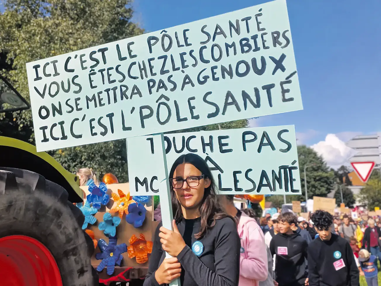 Une manifestante tient une pancarte contre la diminution d'argent pour le pôle santé de la Vallée de Joux