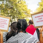 Une manifestante tient une pancarte qui dénonce les liens économiques de la Suisse avec Israël