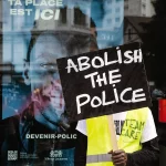 Un manifestant tient une pancarte "abolish the police"