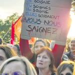 Des manifestantes du secteur de la santé avec une pancarte contre les mesures d'austérité