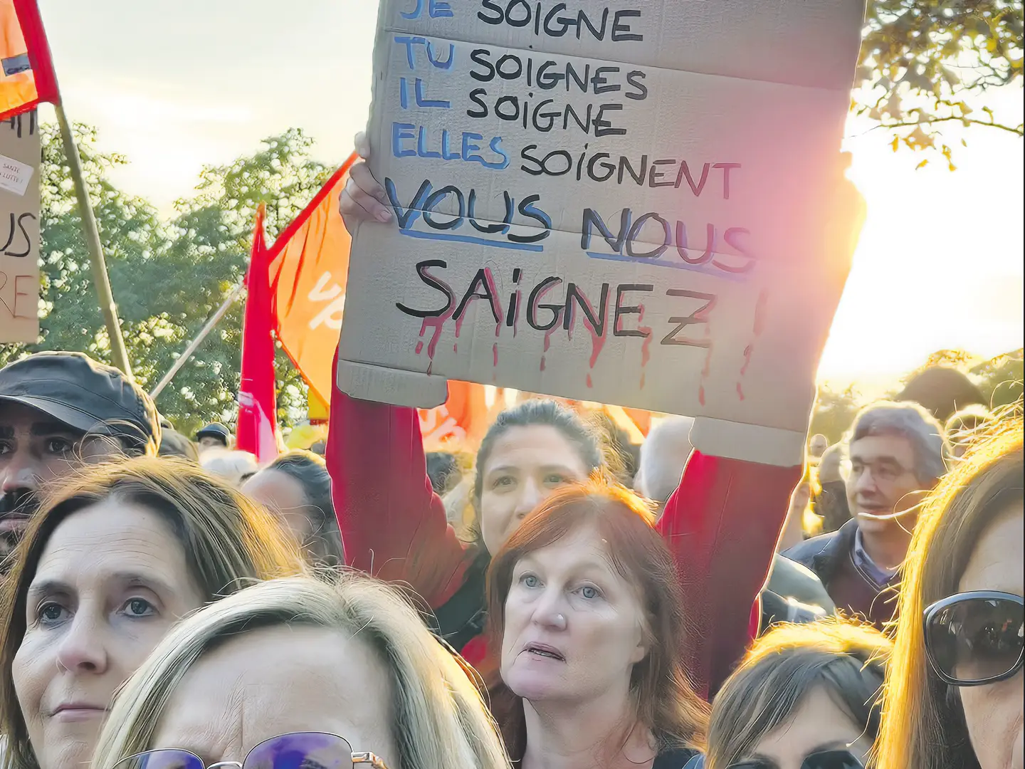 Des manifestantes du secteur de la santé avec une pancarte contre les mesures d'austérité