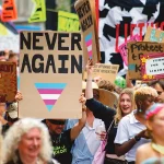 Une pancarte "Never again” dans une pride trans